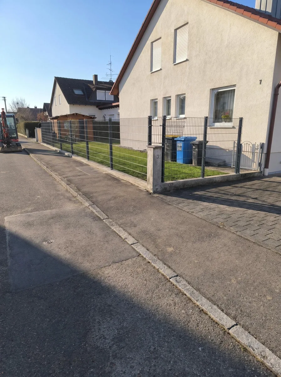 Anthrazitfarbener Doppelstabzaun entlang der Straße